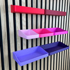Organizer Boxen in Rot, Pink und Lila am Akustikpaneel aus seitlicher Perspektive