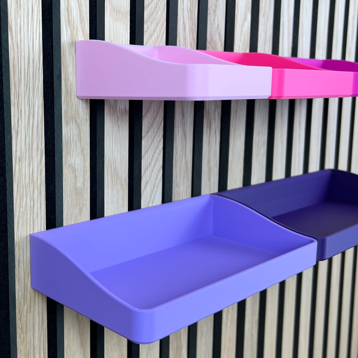 Detailansicht der tiefen Low-Box in Flieder und Pink am Holz-Akustikpaneel