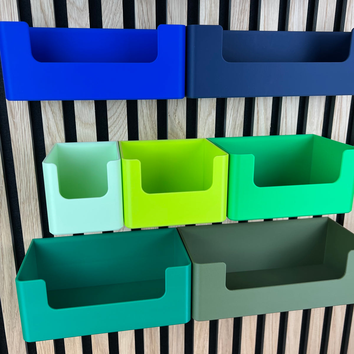 Tiefe Organizer Boxen mit Eingriff in Grün und Blau am Holz-Akustikpaneel