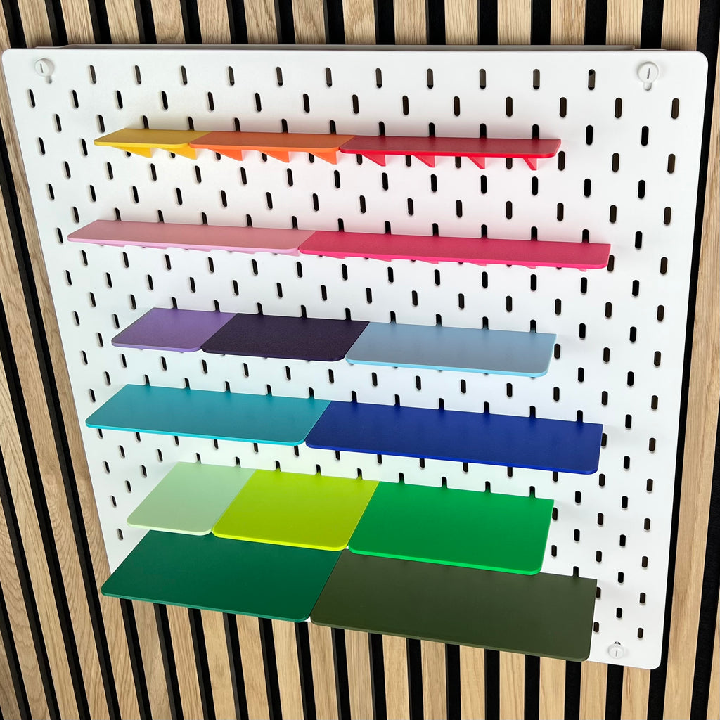 Farbige Ablagen für die IKEA SKÅDIS Lochwand, leicht seitliche Ansicht der sechs Regalreihen