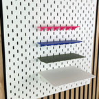 Vier SKÅDIS Ablagen in Pink, Blau, Oliv und Weiß mit zunehmender Tiefe an der Lochwand