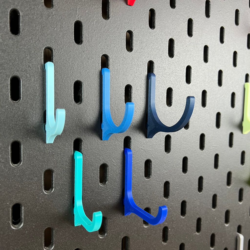 Blaue und türkise 3D-gedruckte Haken für die IKEA SKÅDIS Lochwand in zwei Längen