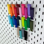 IKEA SKÅDIS Lochwand mit gruppierten Klipp-Halterungen, perspektivische Ansicht vor Holzwand