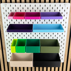 SKÅDIS Boxen in Pink, Violett, Grün, Beige und Schwarz an der weißen Lochwand