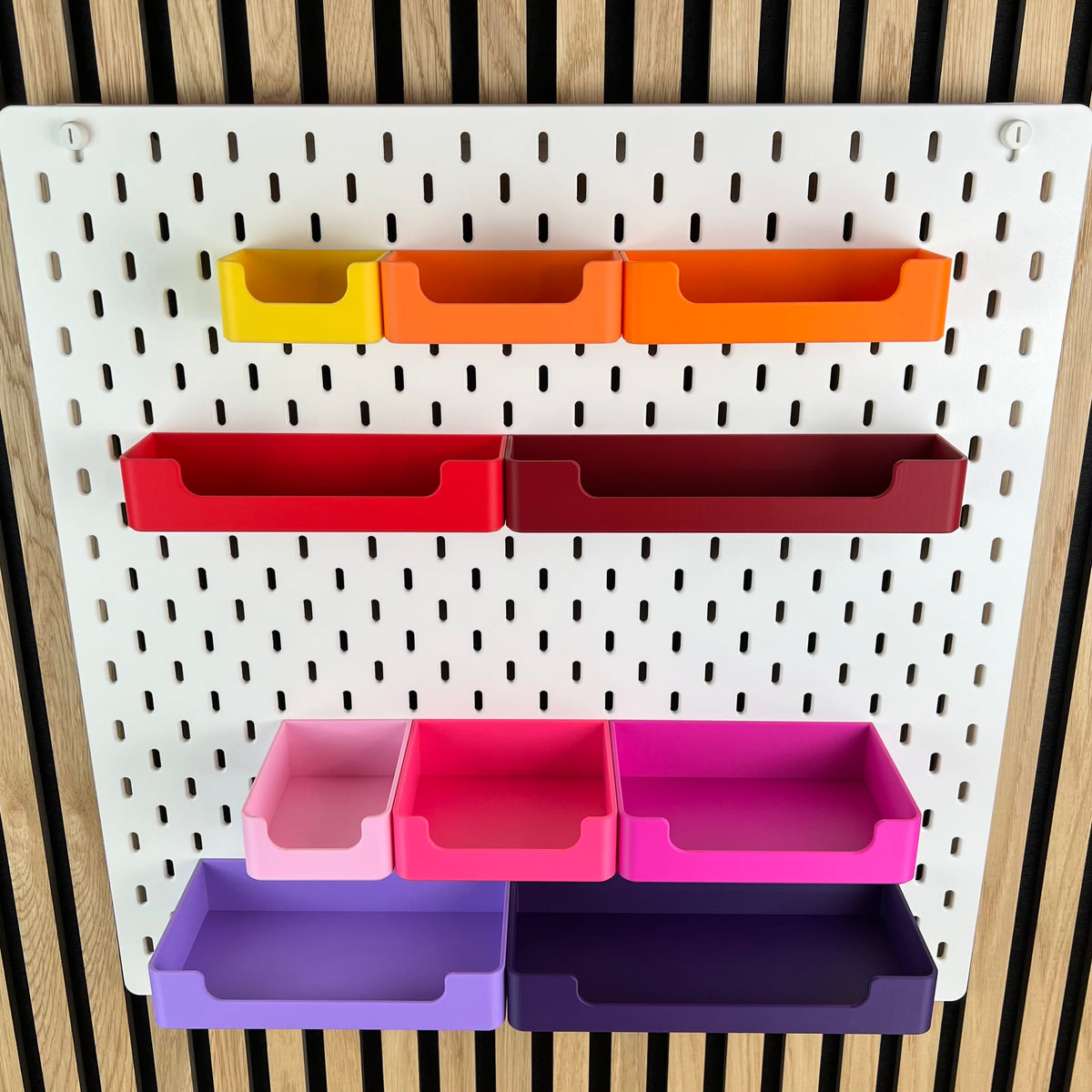 SKÅDIS Boxen mit Griffmulde in Gelb, Orange, Rot, Rosa und Violett, Frontalansicht der Lochwand