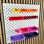 Sichtlagerkästen für IKEA SKÅDIS in Warmtönen, leicht schräge Ansicht vor Akustik-Holzwand