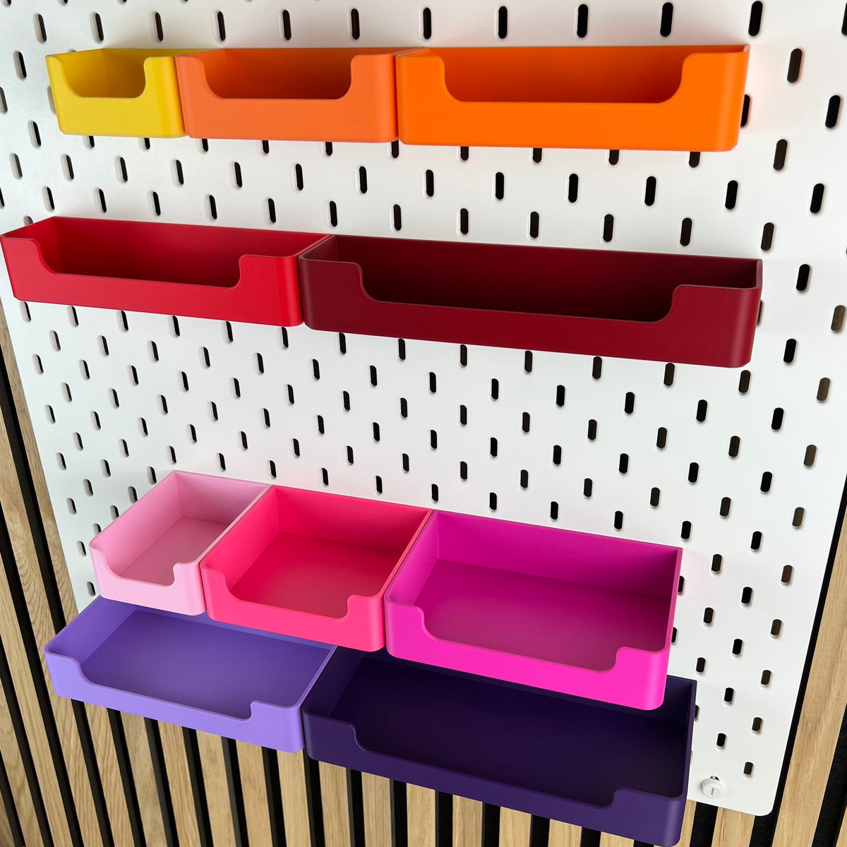 Detailaufnahme der Eingriffsöffnung an SKÅDIS Boxen in Rot, Pink und Violett