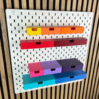 Weiße IKEA SKÅDIS Lochwand mit bunten 3D-gedruckten Schubladen mit Eingriffsloch in mehreren Größen