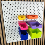 Sechs geöffnete SKÅDIS Schubladen mit Eingriffsloch, Innentiefen in Regenbogenfarben im Vergleich