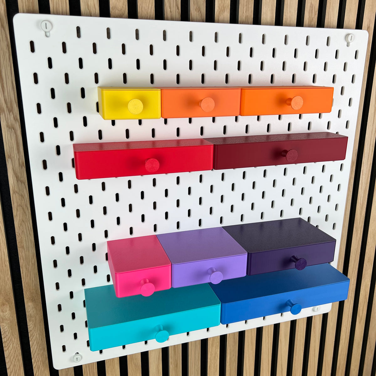 Weiße IKEA SKÅDIS Lochwand mit bunten 3D-gedruckten Schubladen mit Griffknopf in mehreren Größen