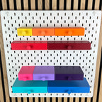 SKÅDIS Schubladen mit Knopf in Gelb, Orange, Rot, Pink und Blau an der Lochwand, Frontalansicht