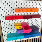 Zwei geöffnete SKÅDIS Schubladen in Gelb und Pink zeigen die nutzbare Innenhöhe