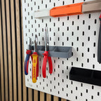 Graue Zangenhalterung mit drei Zangen im Detail an weißer IKEA SKÅDIS Lochwand